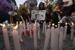 Palestinains light candle in response to Israel's attacks 