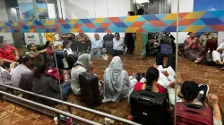 Passengers wait after a San Francisco-bound flight was delayed at the Delhi Airport