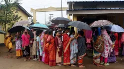 Voters wait in a queue at a polling station to cast their votes.