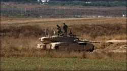 Israeli soldiers on a tank near the Israel-Gaza border