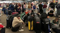 Passengers queue outside Terminal 1 after an overnight power cut led to disruptions and cancellation