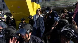 A Pro-Palestinian protestor is detained by New York Police officers outside the Brooklyn Museum.