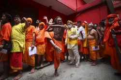 A sadhu poses while waiting to get registered for Amarnath Yatra at Ram mandir base camp, in Jammu