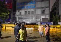 Students stand amid waterlogging in front of Raus IAS Study Circle at Old Rajinder Nagar in New Delhi