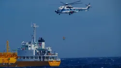 A woman is airlifted by a coast guard helicopter off Nojimazaki, Chiba prefecture, Japan.