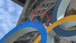 A man climbs the Eiffel Tower, during the 2024 Summer Olympics, Sunday.