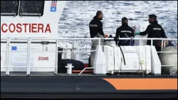 Italian Coast Guard officials bring ashore in a bag the body of one of the victims of the UK flag vessel Bayesian, which sank off the coast of Sicily.