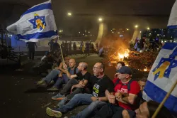 People block a road as they protest calling for a deal for immediate release of hostages held in the