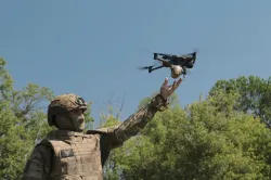 A military personnel posing with drone