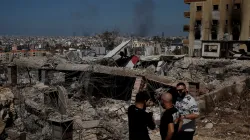 People stand amid damage caused by Israeli airstrikes in Beirut.