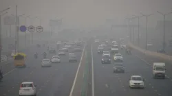 Vehicles ply on the road amid low visibility due to smog