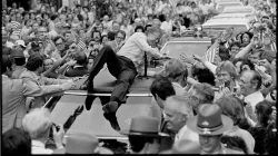 President Jimmy Carter leans across the roof of his car to shake hands along the parade route through Bardstown on July 31, 1979. 