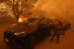 A woman cries as the Palisades Fire advances in the Pacific Palisades neighborhood of Los Angeles