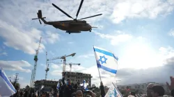 People wave as a military helicopter carrying hostages arrives in Israel.