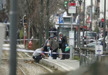 Investigators collect evidence near a tram track in Schaerbeek, Belgium, Friday 
