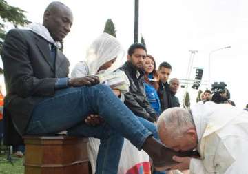 Pope Francis kisses the foot of a man during the foot-washing ritual 