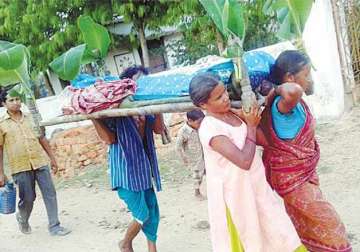 Two sisters carry the body of their mother in a village in Odisha's  Bargarh