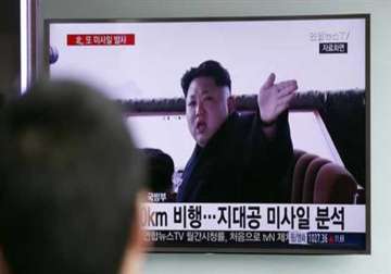 A man watches a TV showing a file footage of  Kim Jong Un at Seoul