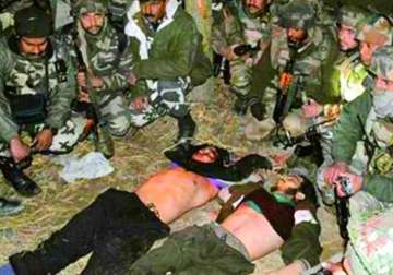 Security forces stand around Pakistani terrorists they killed