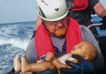 Rescuer carries dead body of 1-yr-old baby drowned in Mediterranean
