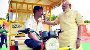 PM Narendra Modi interacts with an e-rickshaw beneficiary in Varanasi