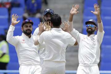 Mohammed Shami celebrates with Virat Kohli and teammates taking a wicket