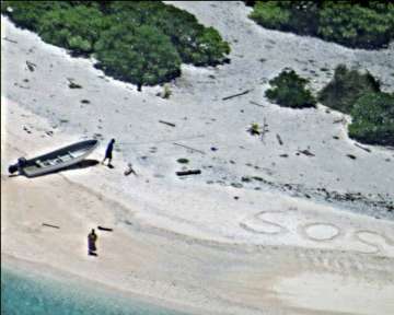Couple rescued from remote desert island after writing SOS message in sand