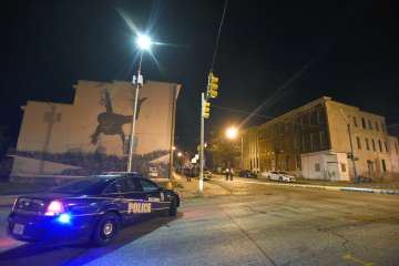 Baltimore police work at a scene where 8 people were shot and wounded