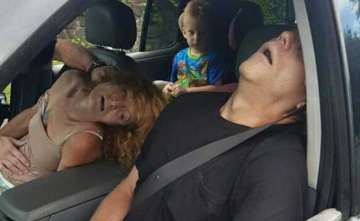 A child sits in a car with his adults unconscious on drug overdose