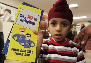 File pic: A Sikh boy displays a placard against bullying of minorities