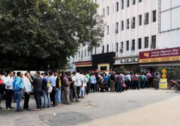 People queue up outside at ATM to withdraw money in New Delhi