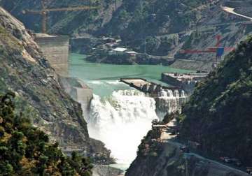 Water flows in Chenab with Baglihar hydroelectric project in background 