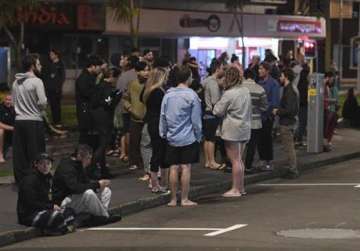 People evacuated from buildings along Dixon Street stand on the street