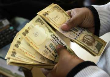 File pic - A man counts now scrapped Rs 500 notes 