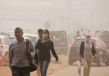 People take protection against pollution as they commute through smog.