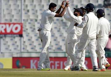 R Ashwin celebrates with team mates dismissal of England's captain A Cook