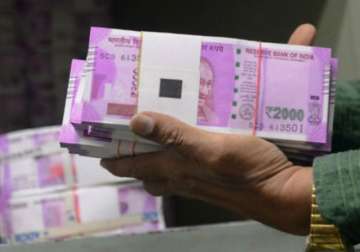 File pic - A bank official carrying new Rs 2,000 notes 