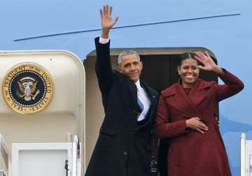 Barack Obama and his wife Michelle wave as they leave Washington