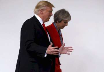 Donald Trump and Theresa May walk along the colonnades of White House