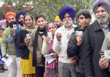 People standing in a queue to cast his vote at a polling station in Punjab