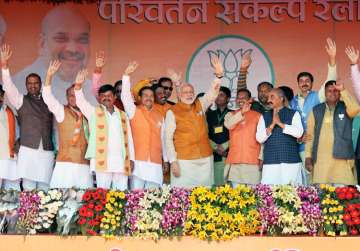Modi with othes BJP leaders waves at crowd at an election rally in Badaun