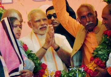 PM Modi being garlanded at an election campaign rally at Jalon district 