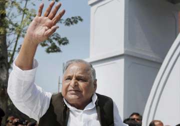 Mulayam Singh Yadav waves to supporters after casting his vote 