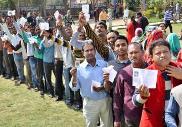 Voters standing in long queues to cast votes at a polling station in UP