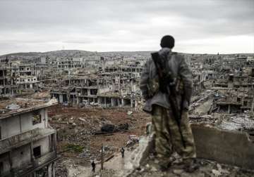 File pic - A Kurdish soldier on top of a building in the destroyed Kobani town