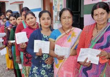 Women stand in line to cast their vote during Uttarakhand assembly election 