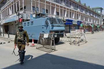 Security jawan stands guards in a deserted street in Srinagar