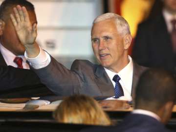 Mike Pence waves as he gets into his car after arriving in Sydney on Friday