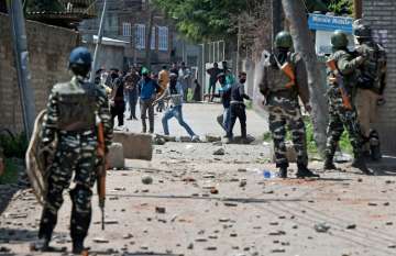 Youths throw stones on Security forces during clashes in Srinagar on Sunday