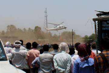 A crowd looks on as the helicopter with Mahrashtra CM on board takes off